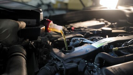 The close-up view of a mechanic changing the car motor oil in a repair shop. During the car inspection or maintenance work - Powered by Adobe