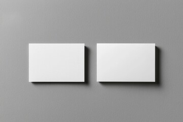 Two blank business cards on a grey background, ideal for branding, corporate identity, and design mockups. Perfect for marketing, advertising, and professional networking