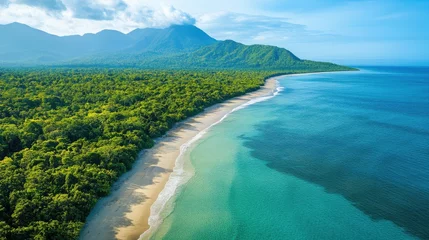 Selbstklebende Fototapeten Tropical coast scene. Mountains and green forest meet sandy beach. Clear water of ocean and bright blue sky. Peaceful landscape. © angelmaxmixam