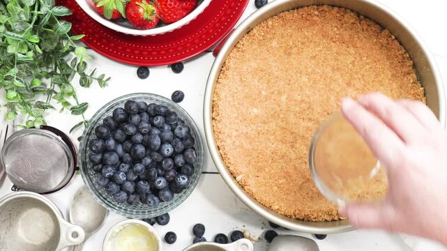 Baking a New York style cheesecake with strawberries, blueberries and a light lemon taste.   Baking a cheesecake in the kitchen with fresh berries.  Easy recipe for a classic cheesecake