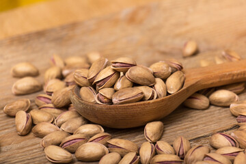 Pistachio nuts on a wooden trencher, natural and healthy snack concept	
