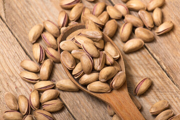 Pistachio nuts on a wooden trencher, natural and healthy snack concept	
