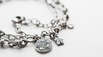 A close-up of a handmade sterling silver bracelet with charms on a white isolated background