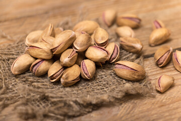Pistachio nuts on a wooden trencher, natural and healthy snack concept	

