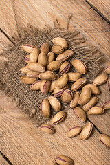 Pistachio nuts on a wooden trencher, natural and healthy snack concept	
