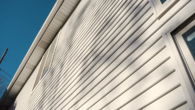 White siding house wall with clean, modern panels, providing a sleek and classic exterior look. Wide view