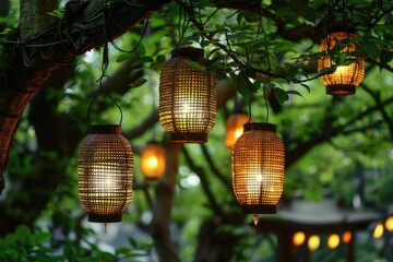 Obraz premium Warm lanterns hanging from tree branches surrounded by green leaves in a serene outdoor setting