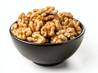 Obraz premium Fresh walnut halves in a black ceramic bowl on a white background