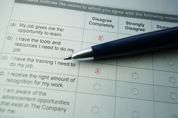 Employment satisfation survey and pen with red x