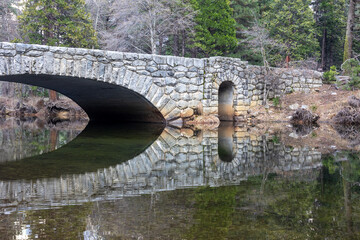 Stone bridge reflected in the merced river in Yosemite