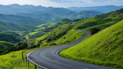 Fototapeta premium A scenic winding road through lush green hills and valleys