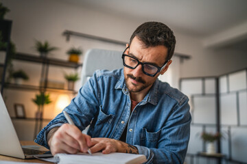 Obraz premium focused concentrated man work on laptop from home office