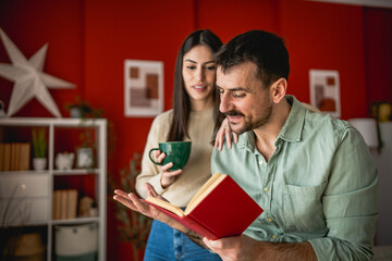 young relaxed couple read book together in living room