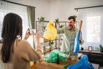woman filming man while hold colorful bags and explain for recycling