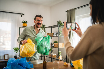 woman filming man while hold colorful bags and explain for recycling