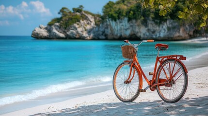 Fototapeta premium Bright orange bicycle parked on a sandy beach with clear blue water and rocky cliffs in background on a sunny day