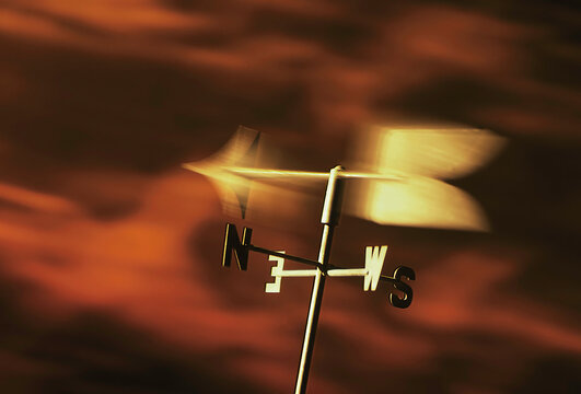 weathervane in windy red dark clouds