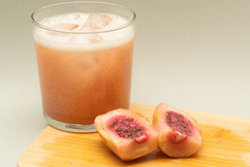 Refreshing xoconostle juice with ice and fruit on wooden board
