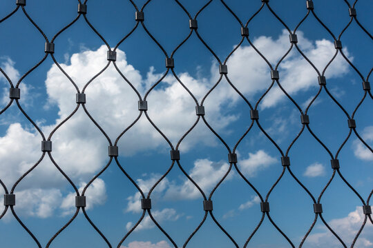 clouds behind mesh fence
