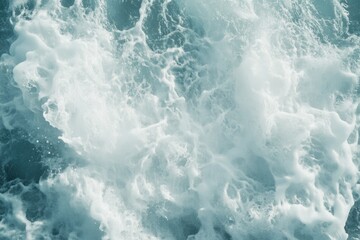 Close-up of ocean waves, white foam and turquoise water creating a dynamic texture.