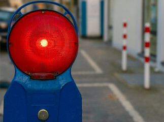 Bright red traffic signal signaling caution on a city street with blurred background details during...