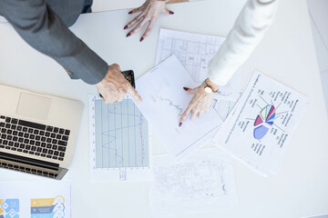 Professionals engage in data analysis, leveraging graphs and charts to strategize and inform...