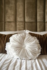 Experience the epitome of elegance in bed decor, showcasing an array of plush pillows and a distinct ruffled accent cushion, all set in a luxurious hotel room atmosphere