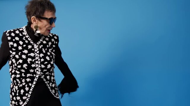 Iris apfel posing and dancing on blue background