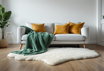 A modern living room with a white couch and green throw blanket on it.