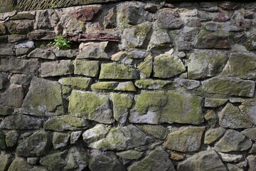 A wall made of stone with moss growing on it