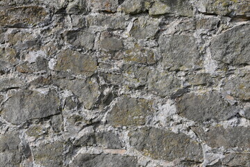 A wall made of stone with moss growing on it