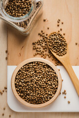Coriander seeds on wooden table.