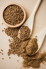 Coriander seeds on wooden table.