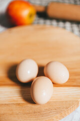 Raw fresh eggs, red apple and rolling pin on wooden table