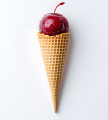 A glazed cherry sits atop an ice cream cone against a clean white background.