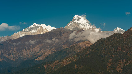 GHOREPANI, NEPAL - JANUARY 9, 2025: Beauty of Annapurna range mountains, view from Ghorepani, warm golden hour light casts a serene glow over stunning landscape.