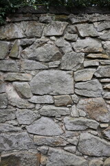 A wall made of stone with a few small holes in it