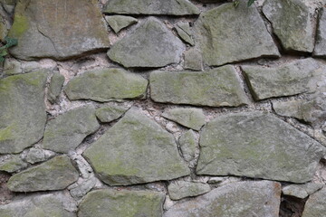 A wall made of stone with moss growing on it