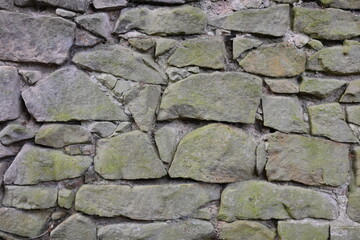 A wall made of stone with moss growing on it
