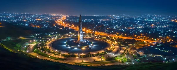 Night shot of Accra, Ghana, with the Black Star Square monument illuminated and the city lights stretching into the distance © seksun
