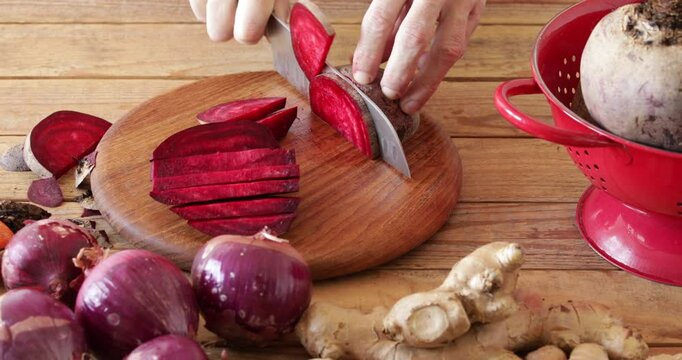 Red beet root, preparing fermented  beet kvass, cutting beet using kitchen knife