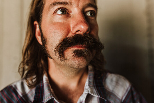 Man with mustache looking up