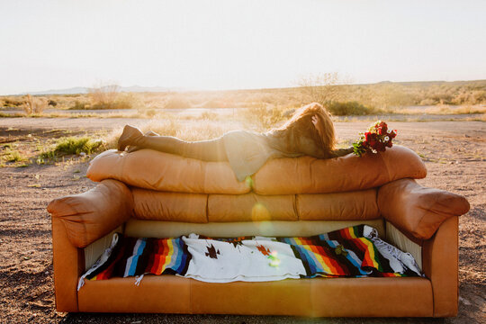 Woman on back of couch in desert with roses