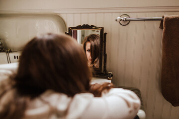 Woman looking at reflection in mirror