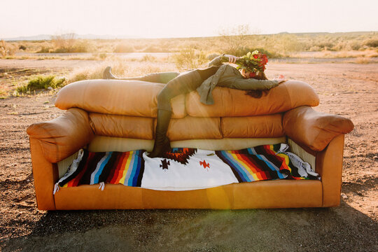 Woman with flowers on couch in desert