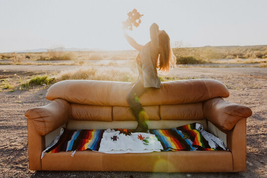 Woman on couch with bouquet of roses