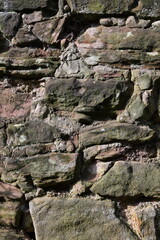 A wall made of stone with moss growing on it