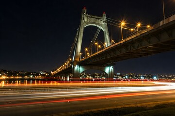 Fototapeta premium A bridge at night, traffic lights blurred into streaks of light.