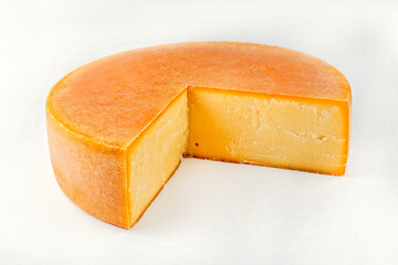 Traditional aged artisan mountain cheese of the European Alps offered as close-up on white background