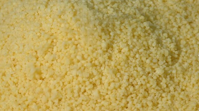 Close-up of yellow dry couscous, top view. a background with space to copy. The concept of vegetarian ingredients for vegans. Another name is Cuscus or Cuz Cuz
